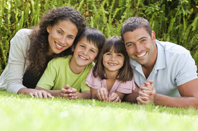 family of four on grass smiling 